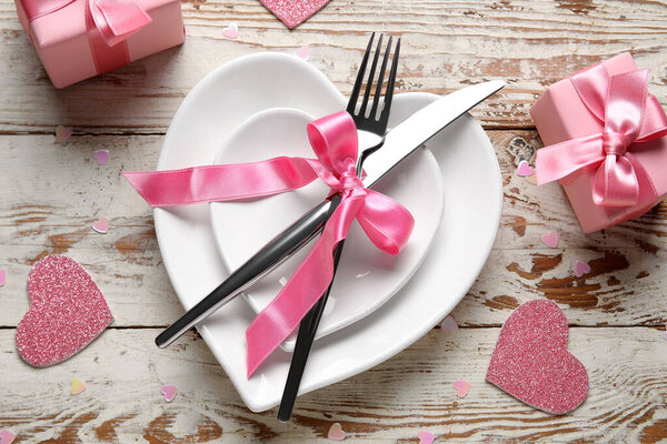 Красивая сервировка стола с сердцами и подарочными коробками на белом деревянном фоне. Празднование Дня Святого Валентина