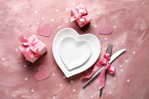 Стол с сердцами и подарочными коробками на розовом фоне. Празднование Дня Святого Валентина