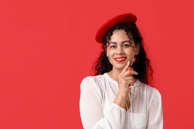 Kırmızı ruj sürmüş mutlu bir Afro-Amerikalı kadın.