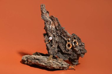 Turuncu arka planda güzel mücevherleri olan bir tahta parçası.