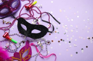 Parti boynuzları, konfeti ve leylak arkaplanlı boncuklu güzel karnaval maskeleri. Üst görünüm