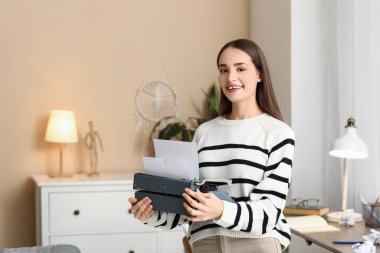 Masasında daktilosu olan güzel, mutlu kadın yazar.