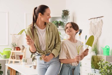 Anne ve oğlu atölyede bahçe aletleriyle.