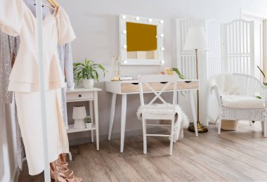 Makyaj odasının içinde makyaj masası, ayna ve katlanır ekran var.