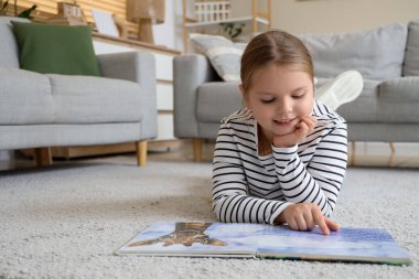 Evde kitap okuyan komik küçük kız.