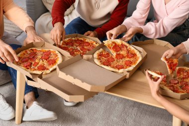 Arkadaşlar evde biberli pizza yiyorlar, yakın plan.