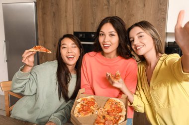 Lezzetli biberli pizzalı bayan arkadaşlar mutfakta selfie çekiyorlar.