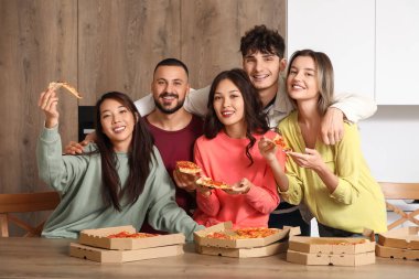 Mutfakta lezzetli biberli pizza olan bir grup arkadaş.
