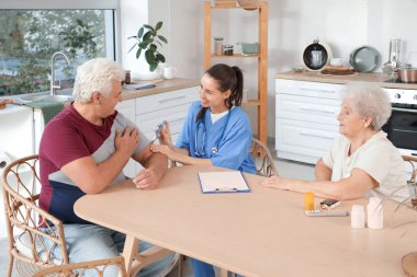 Mutfakta tükenmez kalem kullanan yaşlı bir çift.