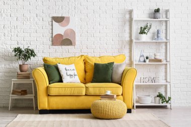 Sarı kanepe ve kitap ve bir fincan kahveyle oturma odasının iç tarafında.