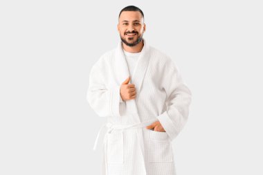 Beyaz arka planda bornozlu genç adam.