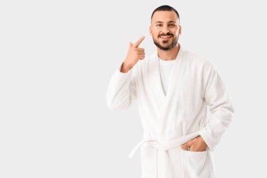 Gülümseyen genç adam beyaz arka planda yüzündeki göz bantlarını gösteriyor.