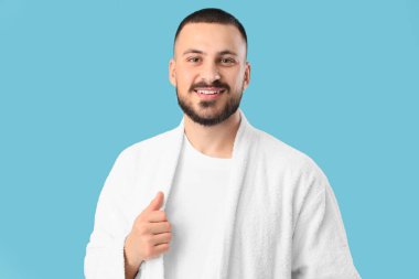 Mavi arka planda cüppeli yakışıklı bir adam.