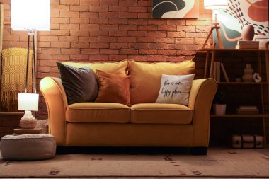 Oturma odasının şık bir iç mekanı. Akşamları kanepe ve parlayan lambalar.