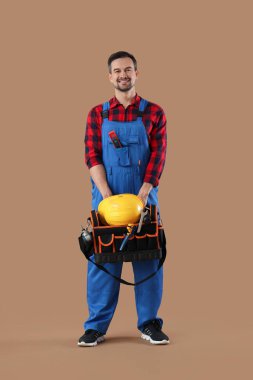 Bej arka planda alet çantası olan erkek teknisyen