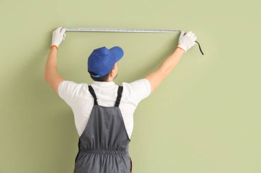 Erkek teknisyen yeşil duvar, arka görüş