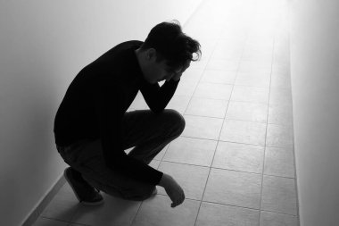 Koridordaki depresif genç adamın siyah beyaz portresi