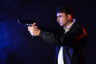 Male FBI agent with gun on dark background clipart