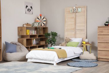 Yatak, raf ünitesi ve armut çantalı çocuk odasının içi.