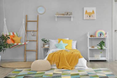 Yatak, raf ünitesi ve merdiveni olan hafif çocuk odası.