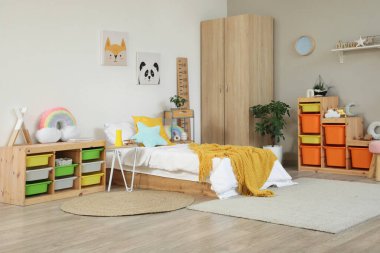 İçinde yatak, raf ve oyuncaklar olan hafif çocuk odası.