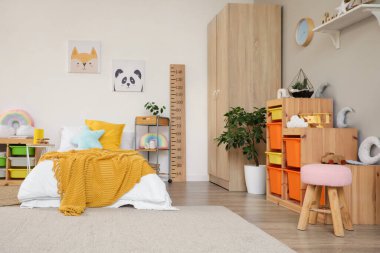 İçinde yatak, raf ve oyuncaklar olan hafif çocuk odası.