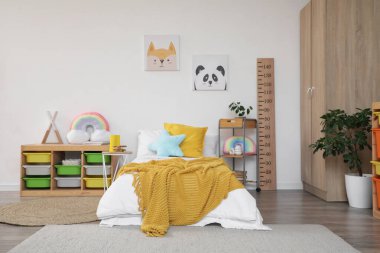 İçinde yatak, raf ve oyuncaklar olan hafif çocuk odası.