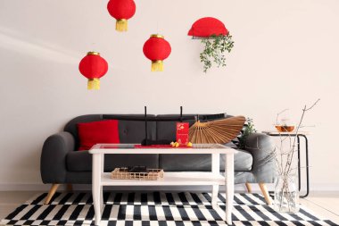 Çin Yeni Yılı için dekore edilmiş oturma odasının içi kanepe ve masalarla dolu.