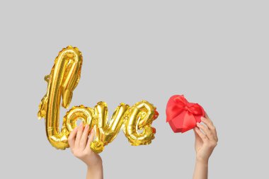 Balon şekilli kadın elleri ve beyaz arka planda aşk ve hediye kutusu. Sevgililer Günü kutlaması