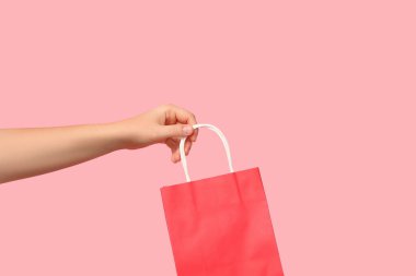 Pembe arka planda kese kağıdı olan bir kadın. Sevgililer Günü kutlaması