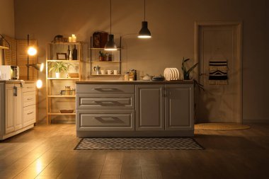 Mutfağın içinde tezgahlar, raflar ve gece lambaları var.