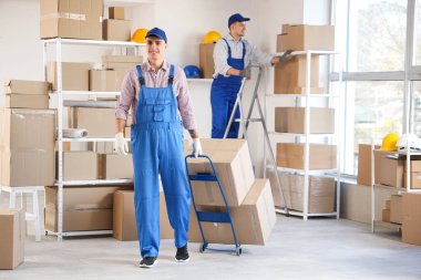 Depoda çalışan erkek yükleyiciler.