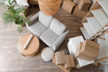 Hareket gününde gri kanepe, masa ve karton kutularla dolu bir oda.