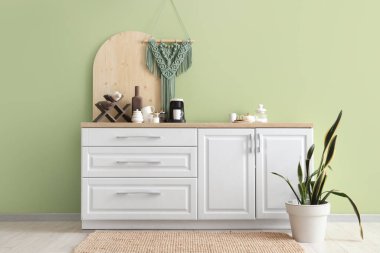 Mutfağın içinde tezgah, kahve makinesi ve bitki var.