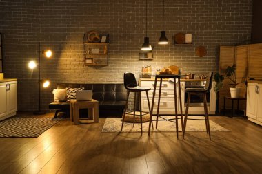 Mutfağın içinde tezgahlar, kanepe ve gece lambaları var.