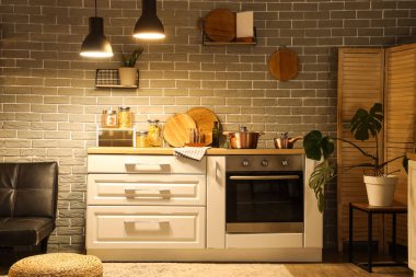 Mutfağın içinde tezgah, bitkiler ve gece lambaları var.