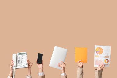 Telefon, cep telefonu, dizüstü bilgisayar ve bej arka planda şemaları olan kadın elleri. Zaman yönetimi kavramı