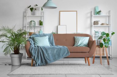 Oturma odasının iç tarafında rahat bir kanepe ve bitkiler var.