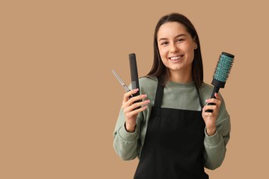 Makasla kadın kuaför, kahverengi arka planda fırça ve tarak.