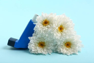 Mavi arka planda kasımpatı çiçekleri olan modern astım spreyi.