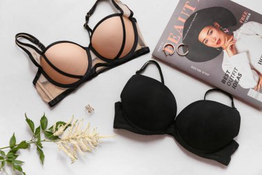 Gri arka planda şık bayan sütyenleri, dergileri ve aksesuarları olan kompozisyon