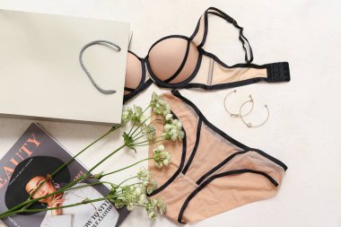 Şık kadın iç çamaşırları, alışveriş çantası, dergi ve çiçekli kompozisyon