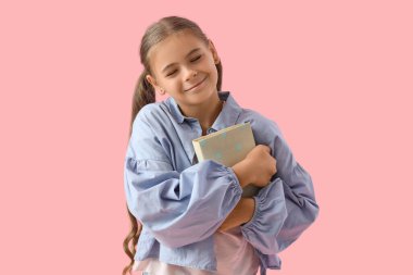 Pembe arka plan kitabı olan tatlı bir kız öğrenci.