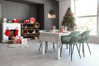 İçinde yemek masası, şömine ve Noel ağacı olan bir oda.