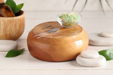 Açık arkaplanda akupunktur iğneleri, deniz tuzu ve spa taşları