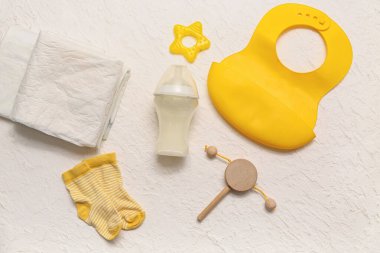 Bebek için bir şişe süt ve hafif arka planda aksesuarlar içeren kompozisyon