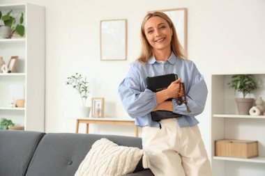 Evde dua boncukları ve İncil 'i olan olgun bir kadın.