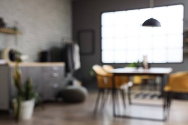 Masası, askısı ve tezgahı olan giyim mağazasının bulanık görüntüsü