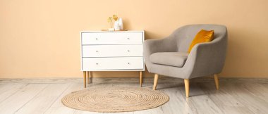 Bej duvarın yanında rahat koltuğu ve tuvaleti olan modern odanın içi