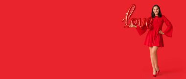 Beautiful young woman holding balloon in shape of word LOVE on red background with space for text. Valentine's Day celebration